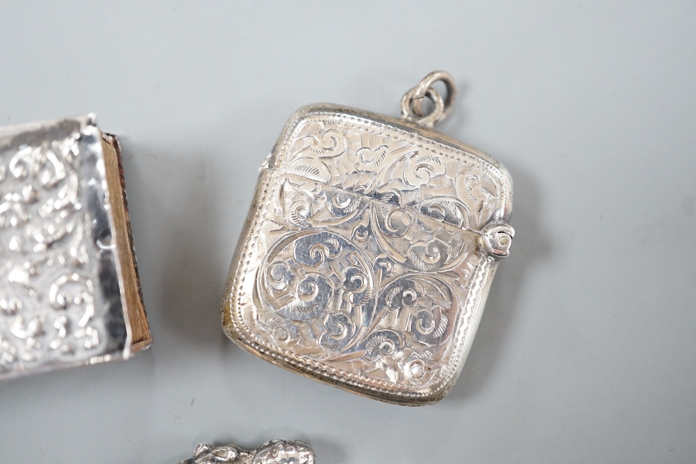 A late Victorian novelty white metal propelling pencil, modelled as a tennis racket, by Sampson Mordan & Co, 64mm, together with a watch case, silver vesta case, spoon and silver matchbox sleeve.